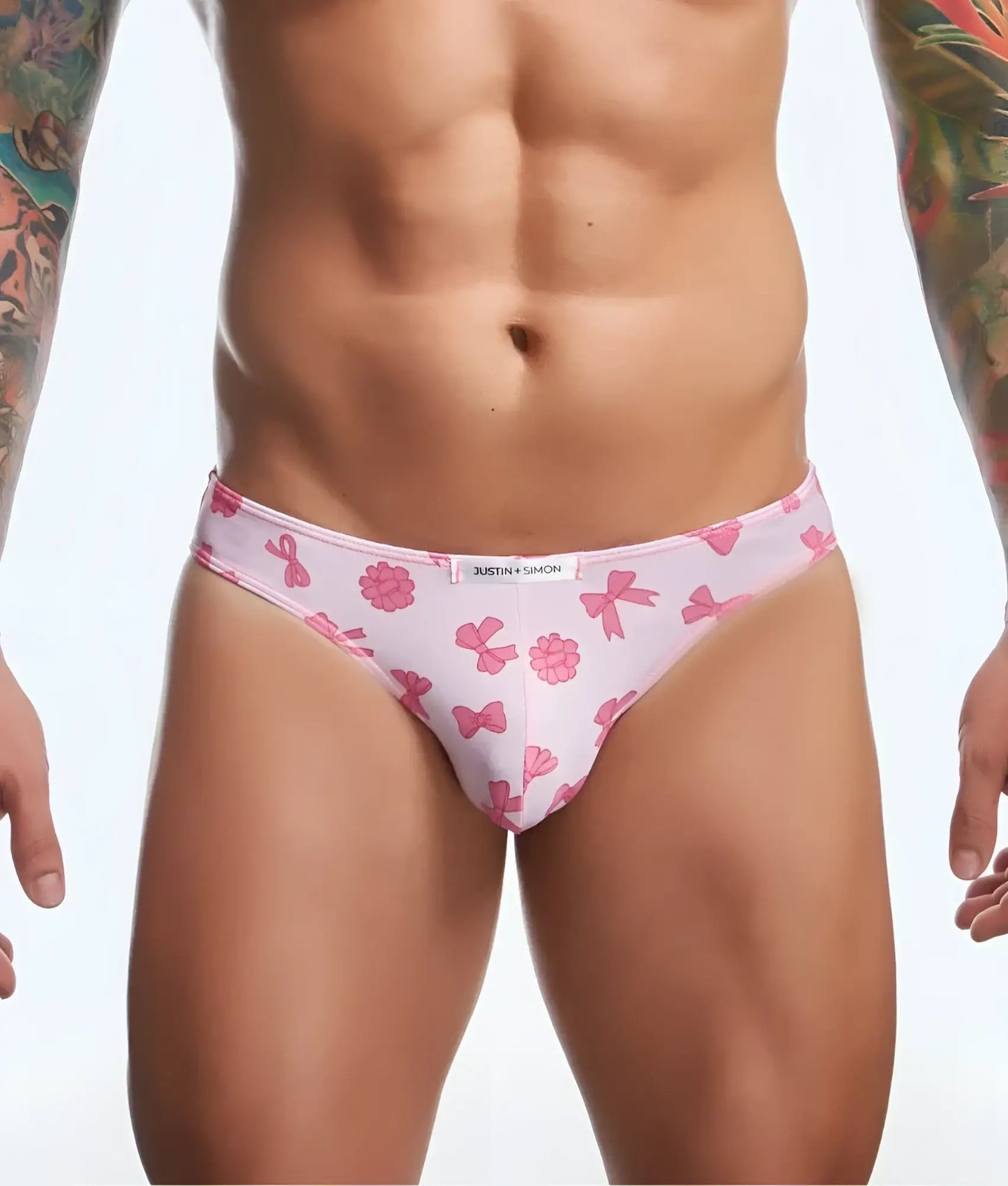 Pink patterned briefs with bow and flower designs and white brand tag from justin + simon classic mens bikini fun prints