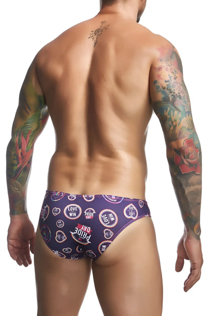 Purple patterned swim trunks by justin simon with love win pride day text and heart motifs from the classic bikini color pride line