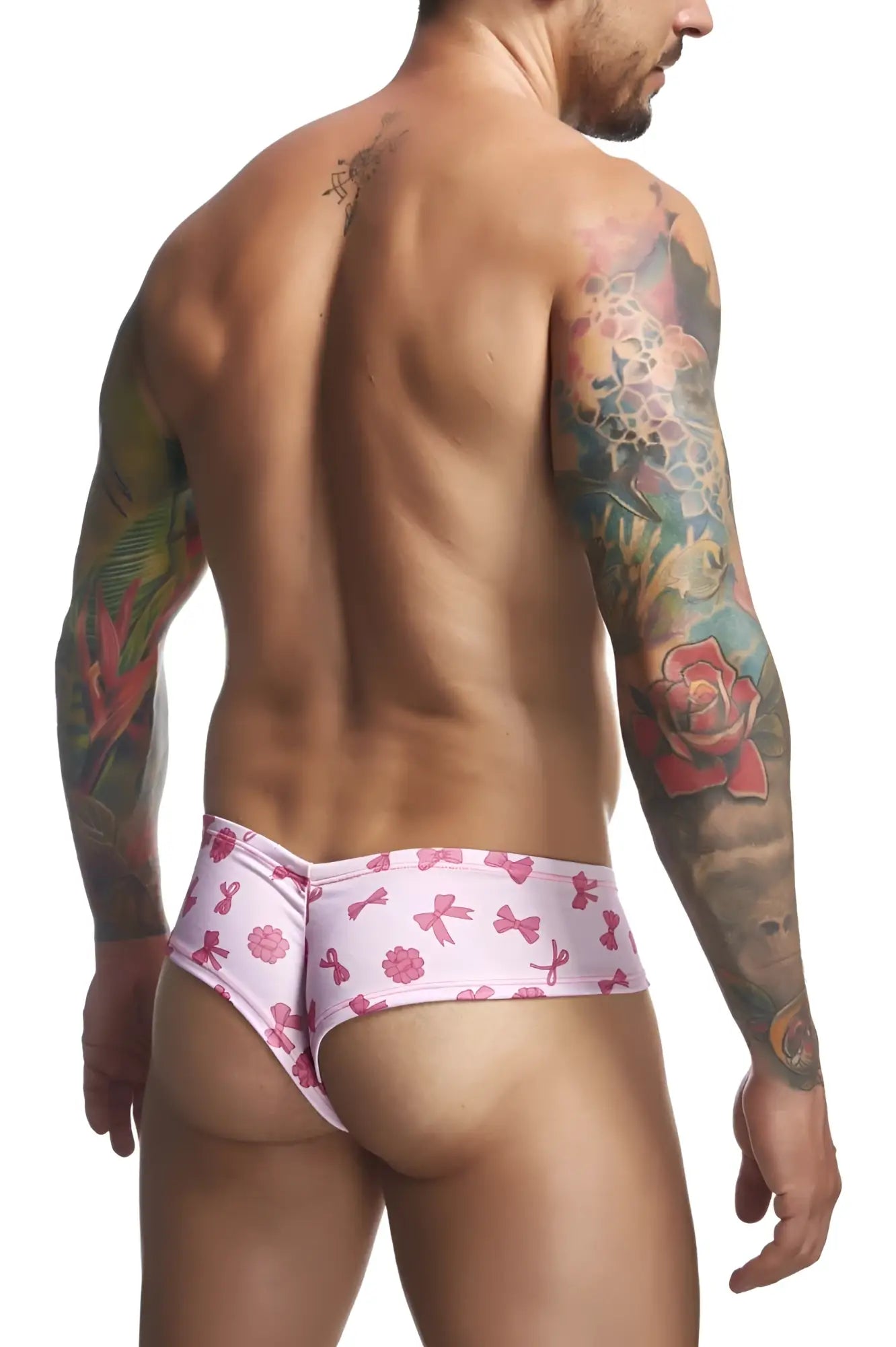 Justin+Simon XSJ22 cheek briefs in pink patterned swim trunks with playful bows and flowers design in coquette color