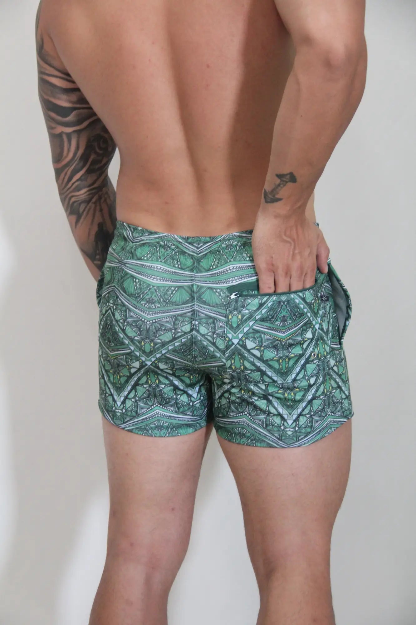 Kaleidoscope shorts green patterned swim trunks with geometric and tribal designs in teal white and dark green