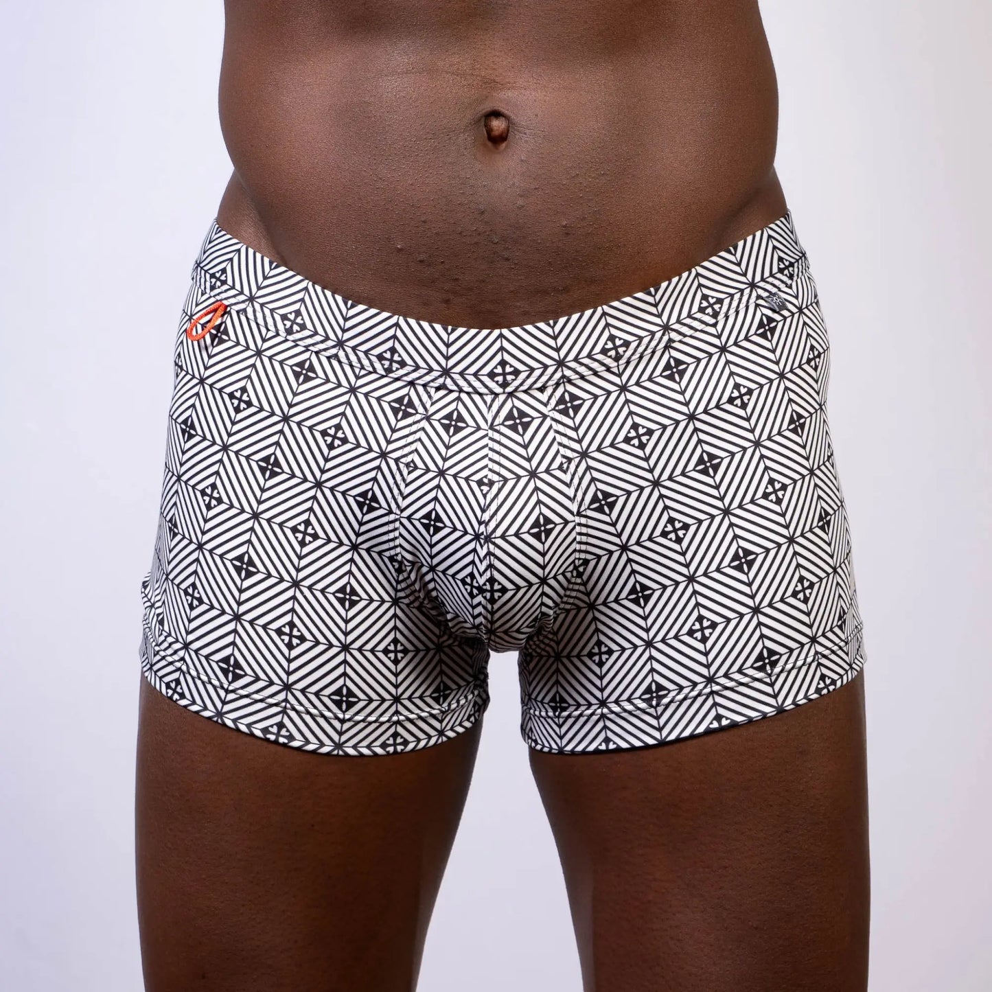 Black and white geometric patterned kaleidoscope sq cut trunk boxer briefs with subtle orange logo on waistband
