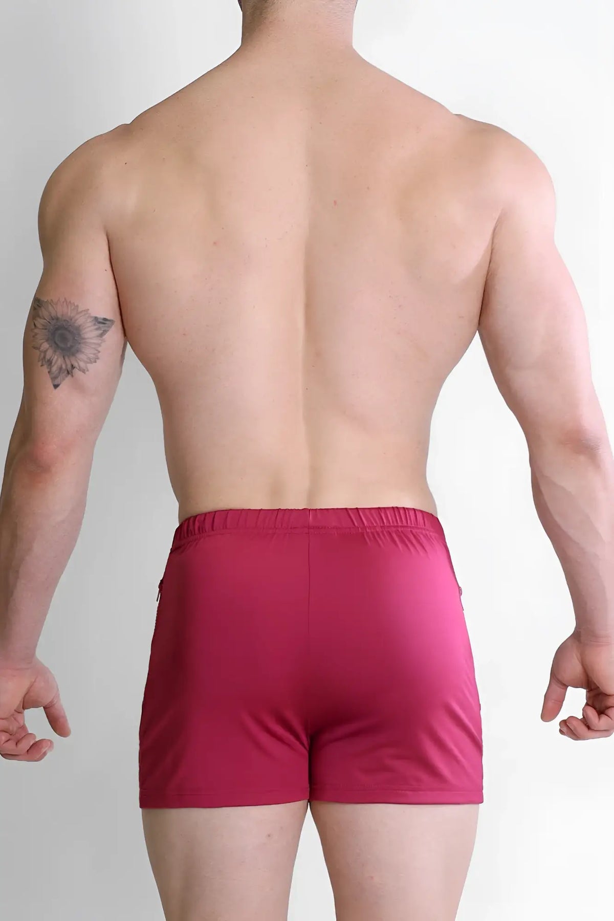 A pair of magenta karma 2 inch short shorts with smooth stretchy fabric elastic waistband and zipper pockets