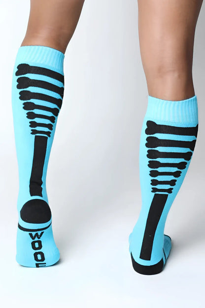Light blue kennel club bones knee high socks with black skeletal ribcage design and wool printed on the heel