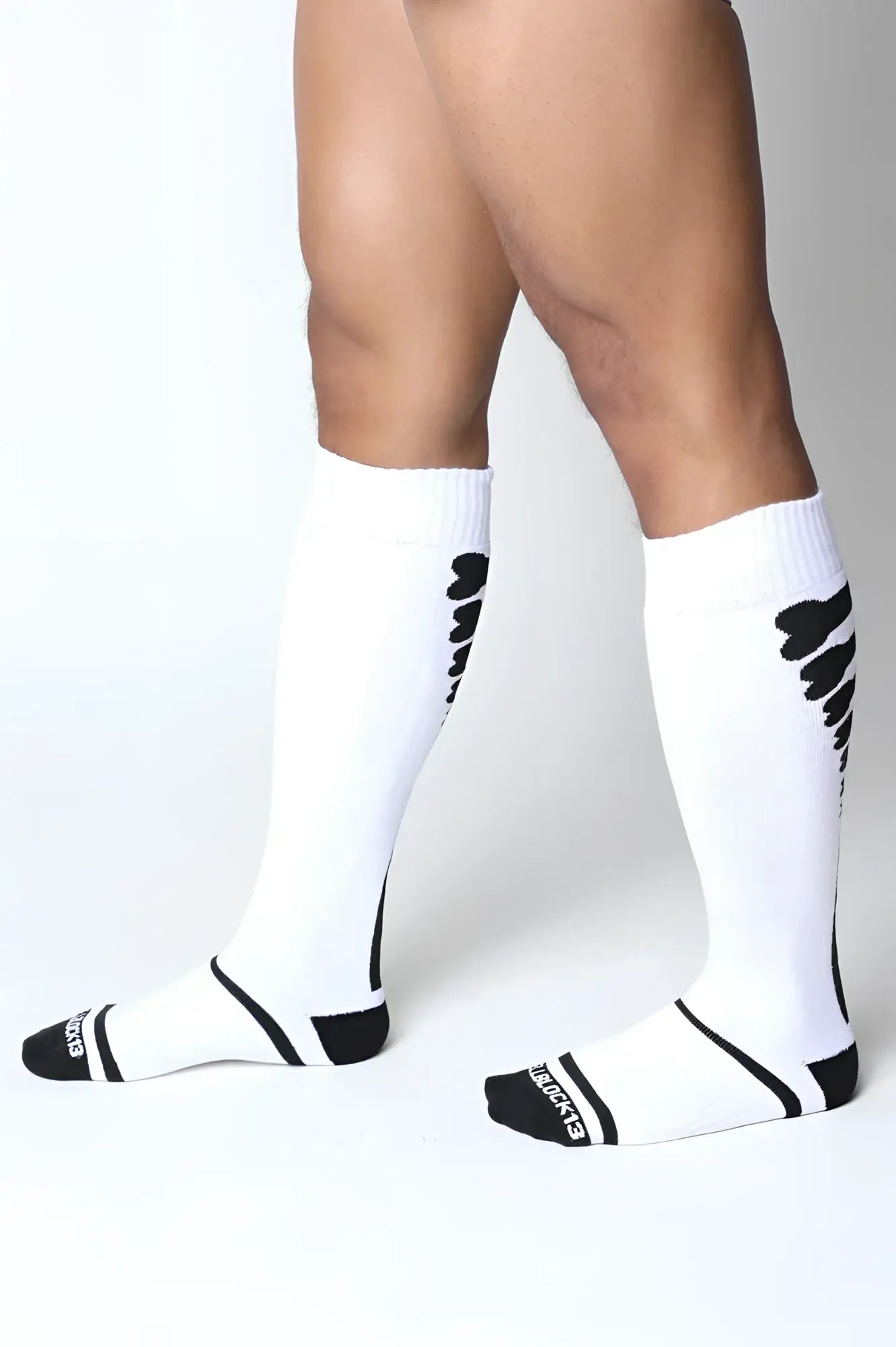 White kennel club bones knee high athletic socks with black wing patterns and branding on the heel back view