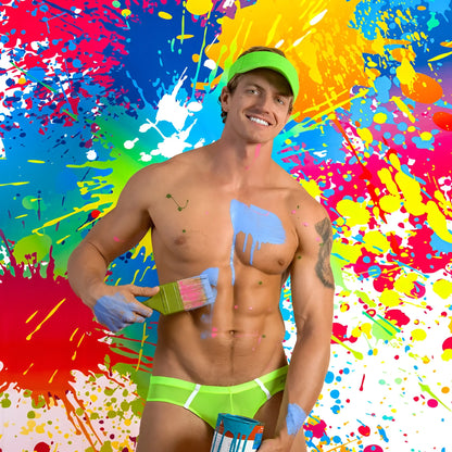 A muscular man wearing neon green kyle kli045 bikini brief swim trunks with matching visor covered in colorful paint