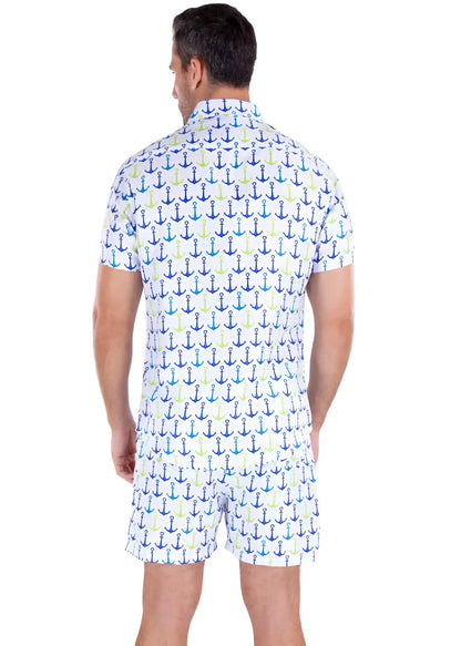 A man wearing a white life’s better on a boat s s shirt and shorts with blue teal and light green anchor patterns