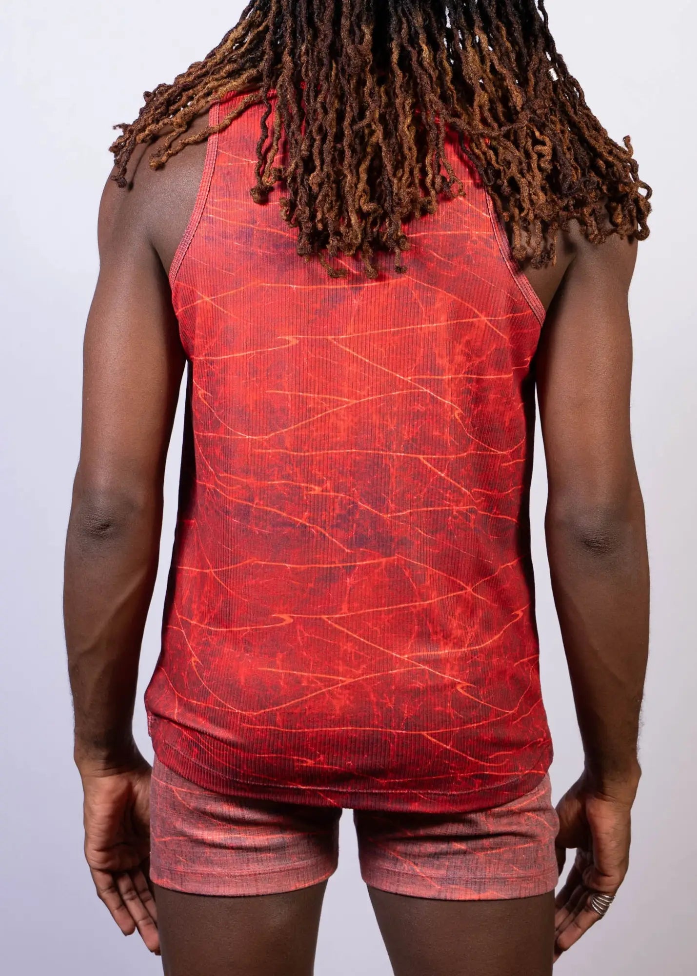 Red tank top with cracked marble pattern in darker red and orange hues called lightning print tank