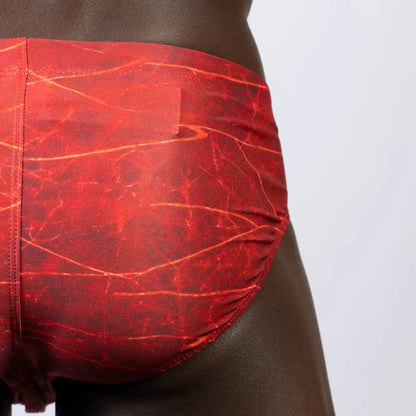 Red lightning swim brief with marbled pattern and subtle orange veining designed for swimming and beachwear