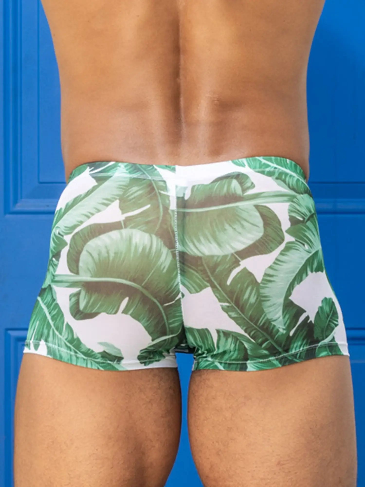 Little boy blue design chris square cut mesh swim trunks with green banana leaf pattern on white background