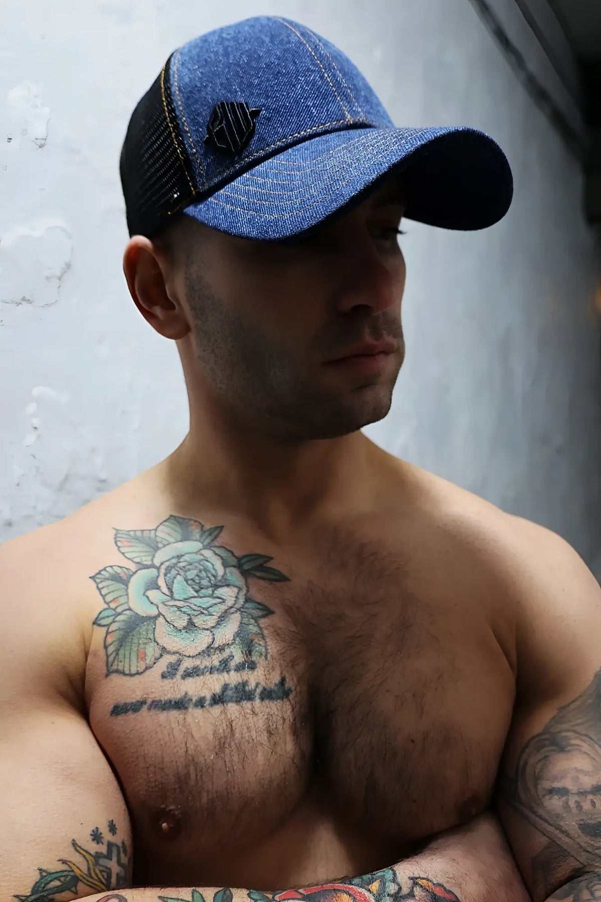Blue denim loaded denim trucker hat with black mesh back and small embroidered logo on front