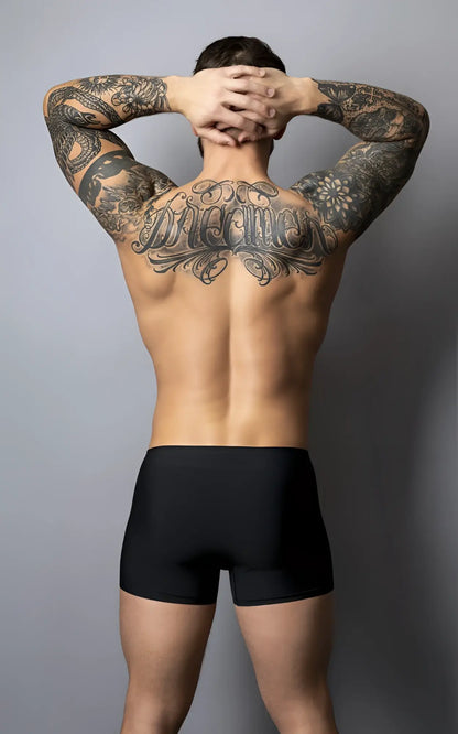 A man wearing male power 154-300 hot mesh pouch short black red showing the back with black ink tattoos