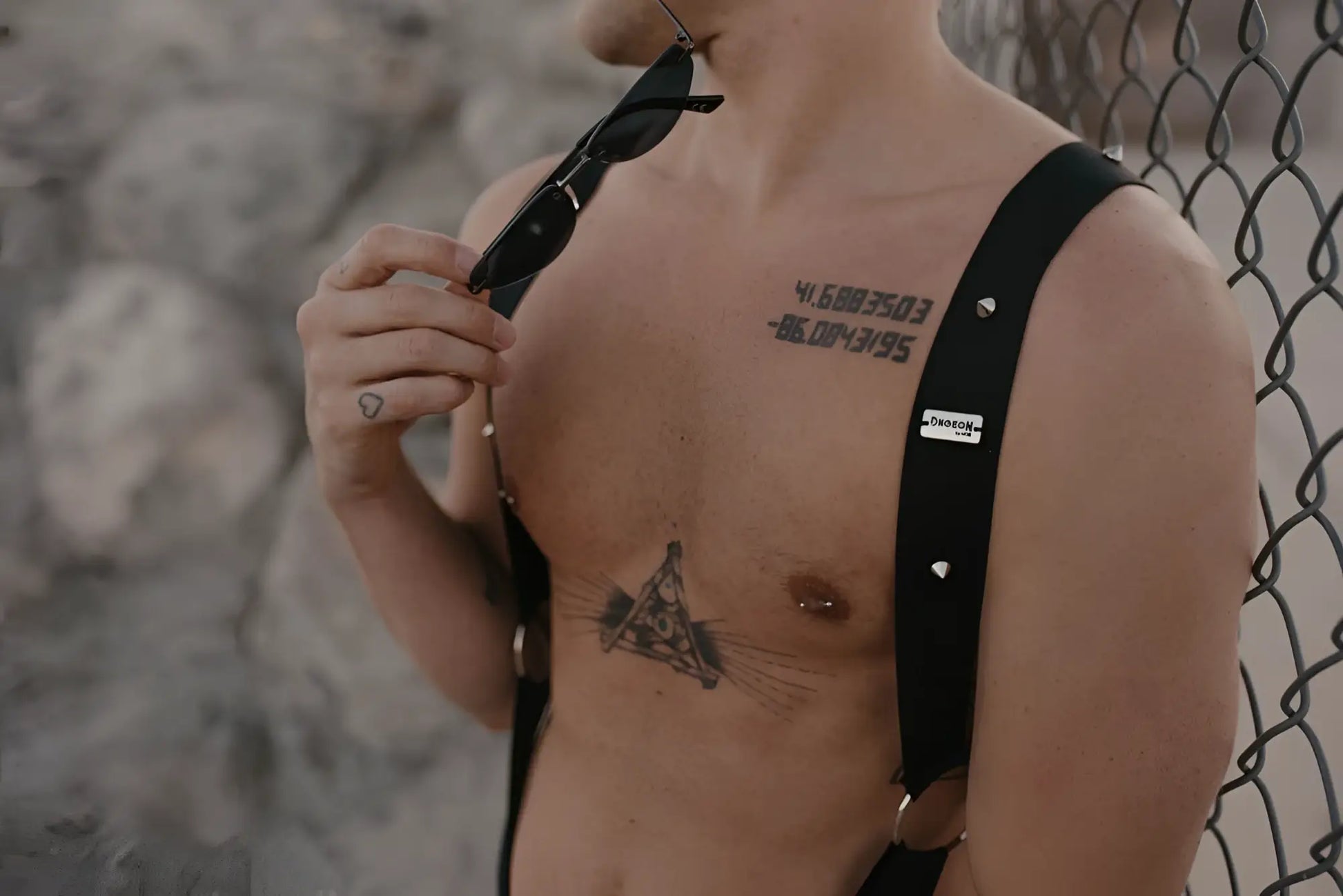 Black leather malebasics dmblo5 dngeon crossback harness with silver studs and a small white label visible on back