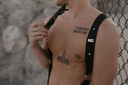 Black leather malebasics dmblo5 dngeon crossback harness with silver studs and a small white label visible on back