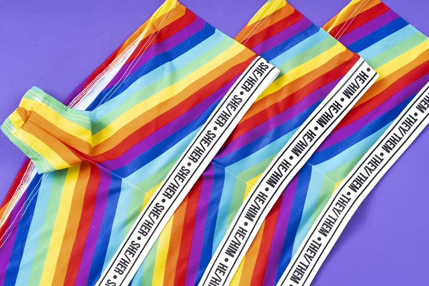 Mapale 122b rainbow cheeky short color leggings featuring rainbow stripes and a white elastic waistband with she her and they they text