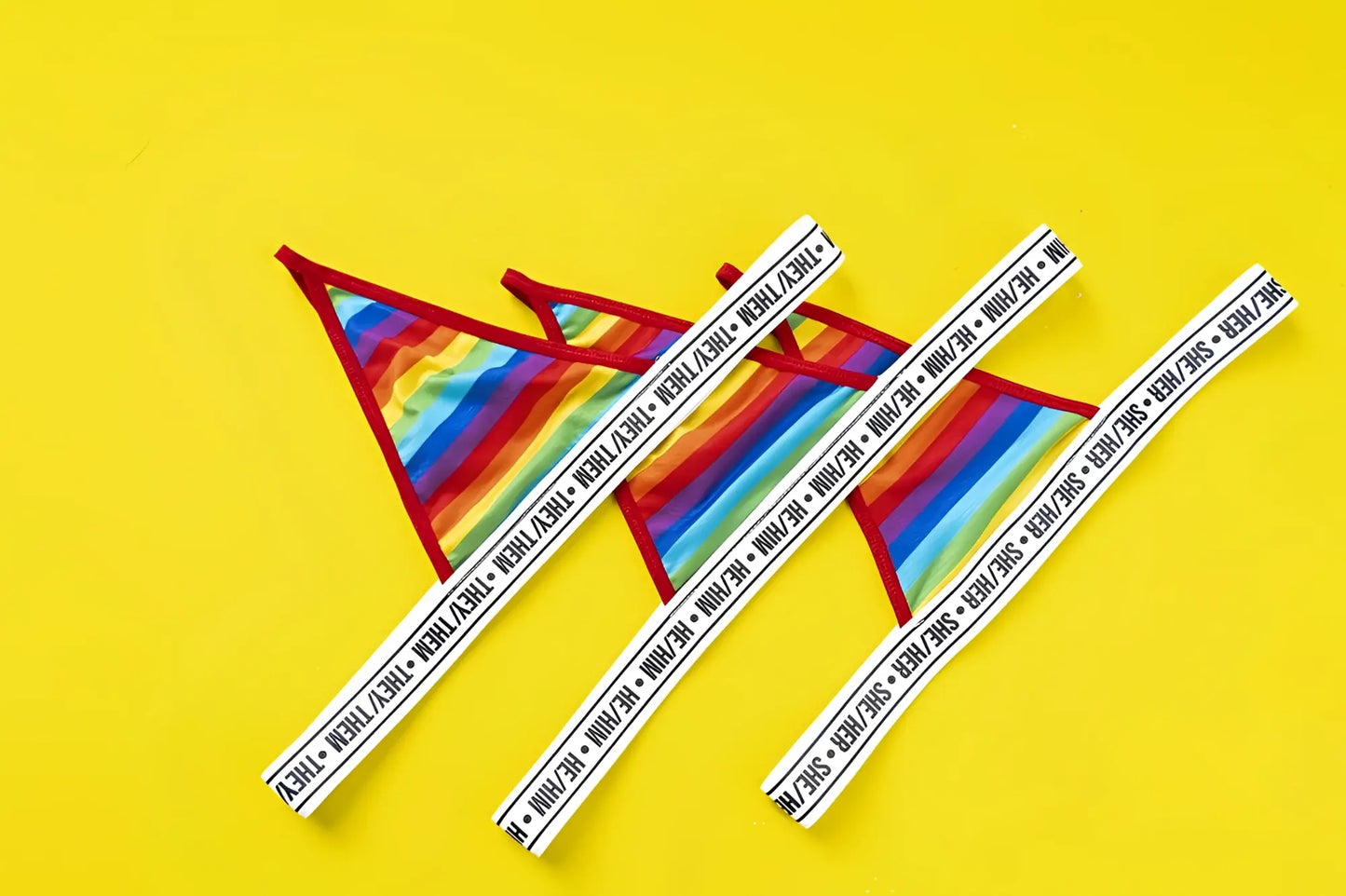 Mapale 123c rainbow thong featuring rainbow stripes red trim and white elastic waistband with repeating they thm text