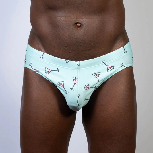 Mint green martini swim brief with playful pink martini glass pattern and black outlines perfect for swimming