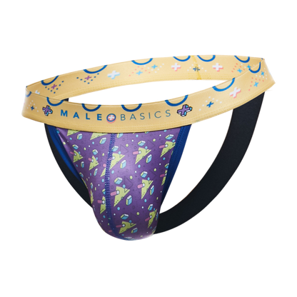 A men's thong-style brief from MaleBasics featuring a purple front pouch with a colorful space-themed print of planets, stars, and crystals, a beige waistband with blue crescent moons and stars, and a black elastic back support strap, shown on a plain white background.