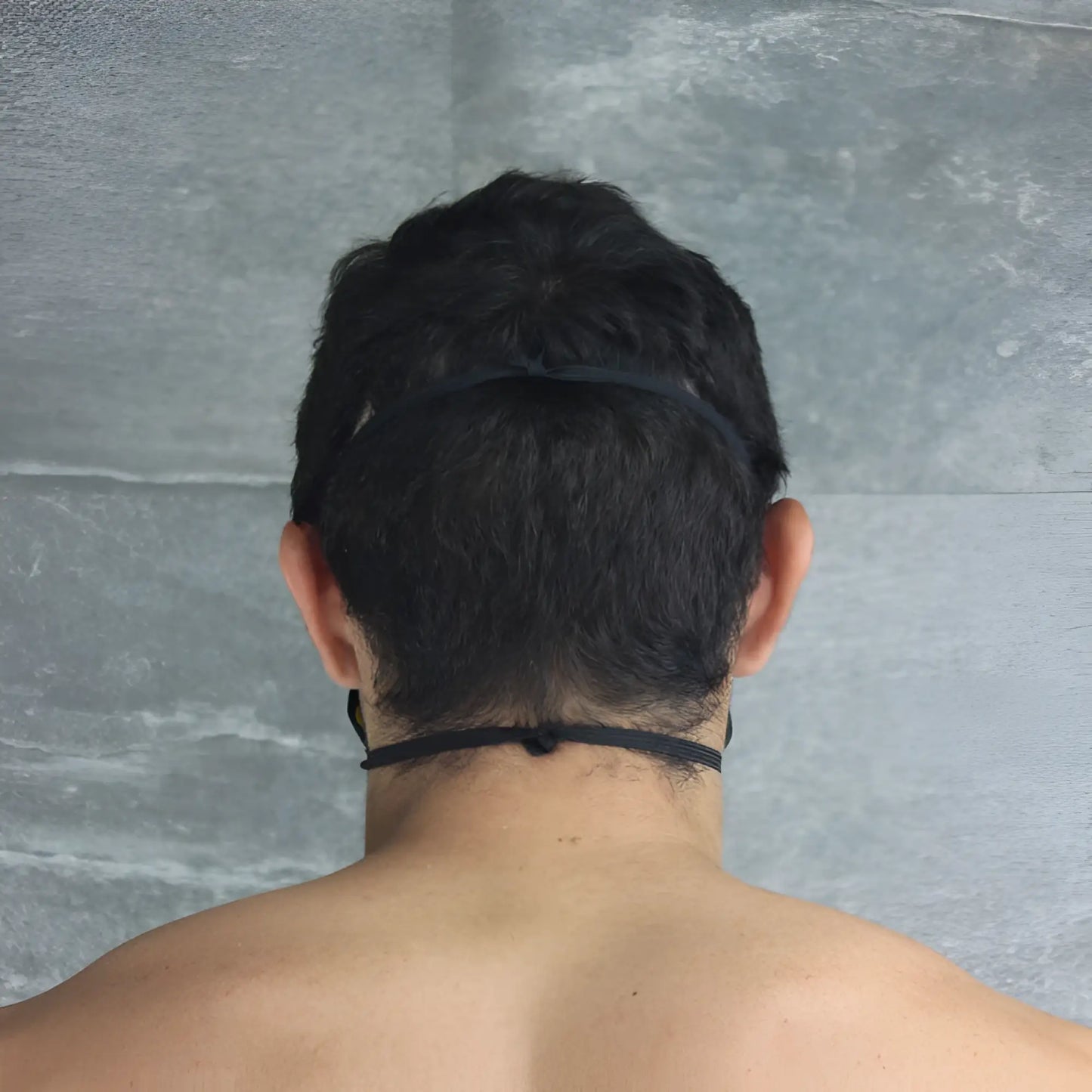 Back view of mckillop polypropylene unisex yellow face mask with black elastic headband one size fit