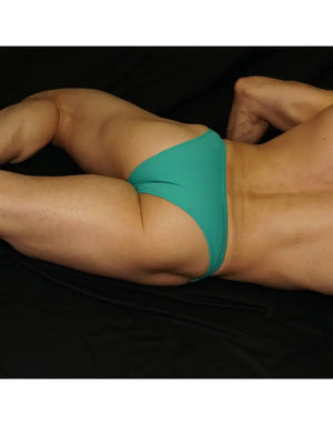 Turquoise micro bikini underwear by Arroyman featuring a low-rise cut and smooth fabric shown on a model.