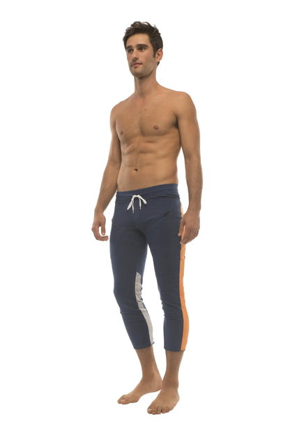 Mens royal navy blue 4/5 zipper pocket capri yoga pants with white and orange side stripes and drawstring waistband