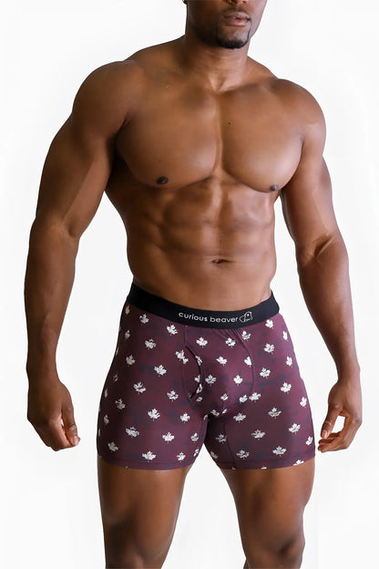Menâ€™s maroon boxer briefs with white maple leaf pattern and black curious beaver waistband canada flag design