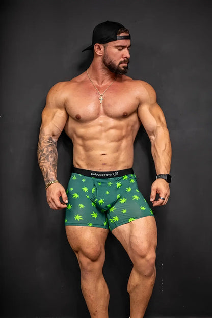 Menâ€™s green boxer briefs with bright lime cannabis leaf pattern and black elastic waistband with curious beaver logo