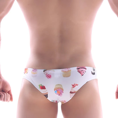 White MetroMaleWear Capri bikini swim trunks with colorful cupcake and frosting pattern for playful beachwear