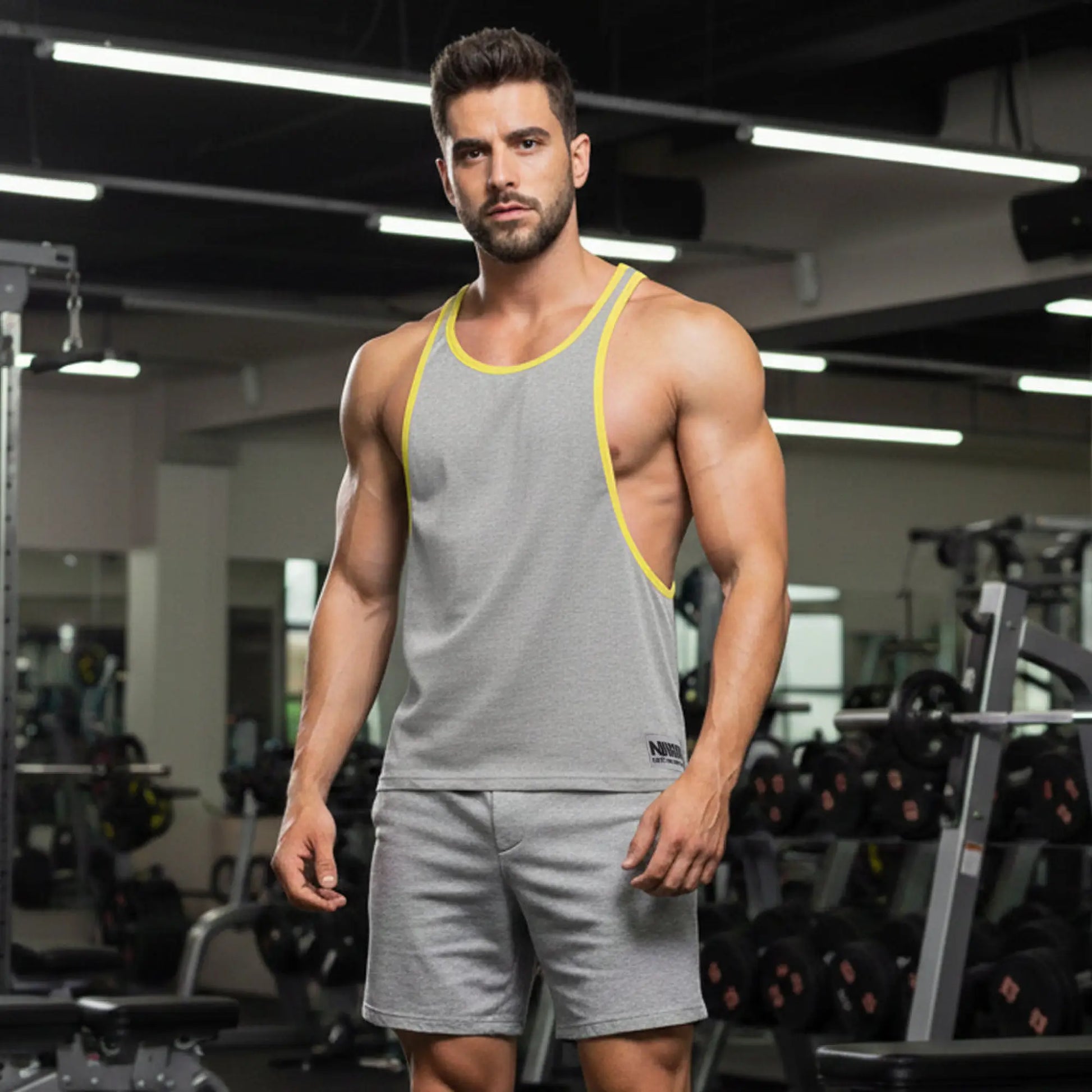 Gray athletic tank top metro malewear with yellow trim and small black logo on lower left side for gym use