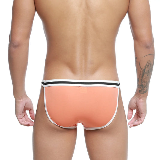 Coral-colored metro malewear link bikini briefs with white and black striped waistband in front view