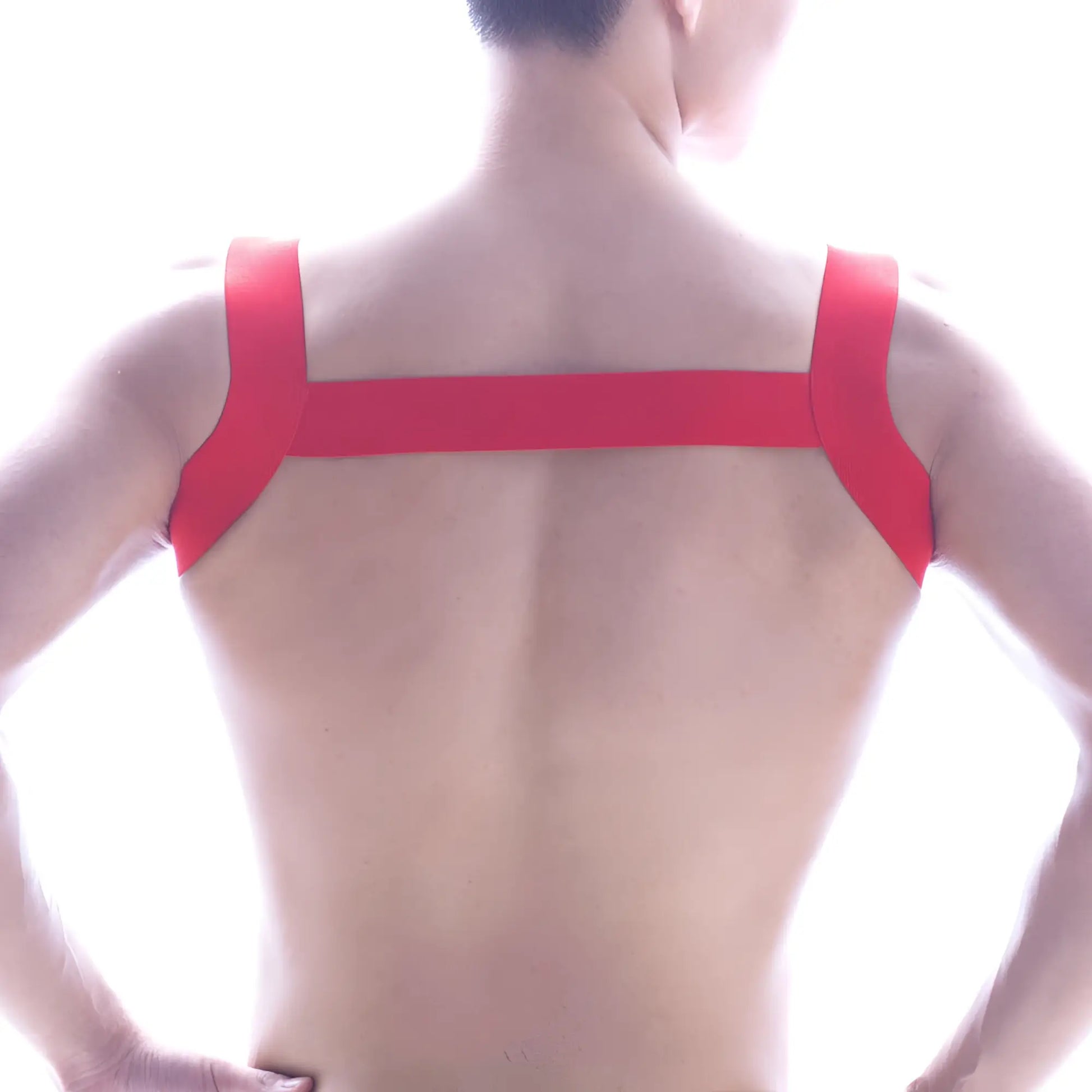 Back view of metromalewear logo harness red adhesive tape strapped in an x-shaped pattern on a person’s back
