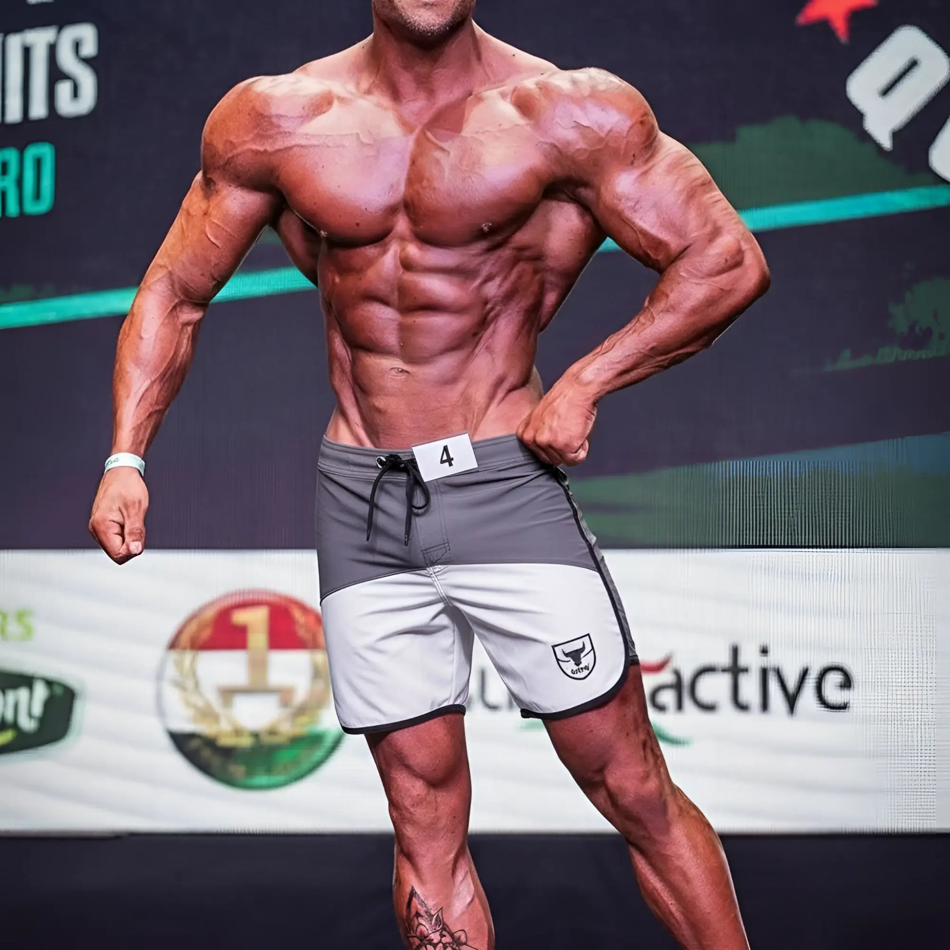 Gray and white metromusclewear cordoba physique board short with black drawstring and shield logo on left leg