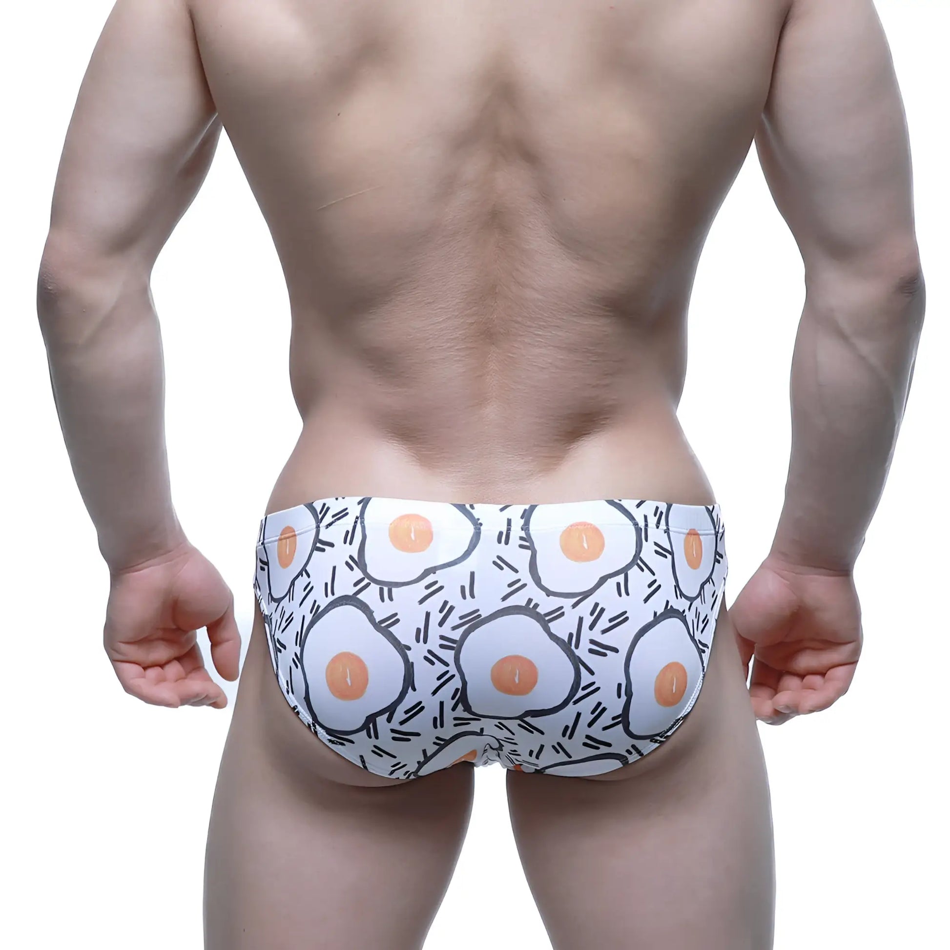 White swim trunks by metromalewear with playful fried egg pattern accented by black outlines and lines