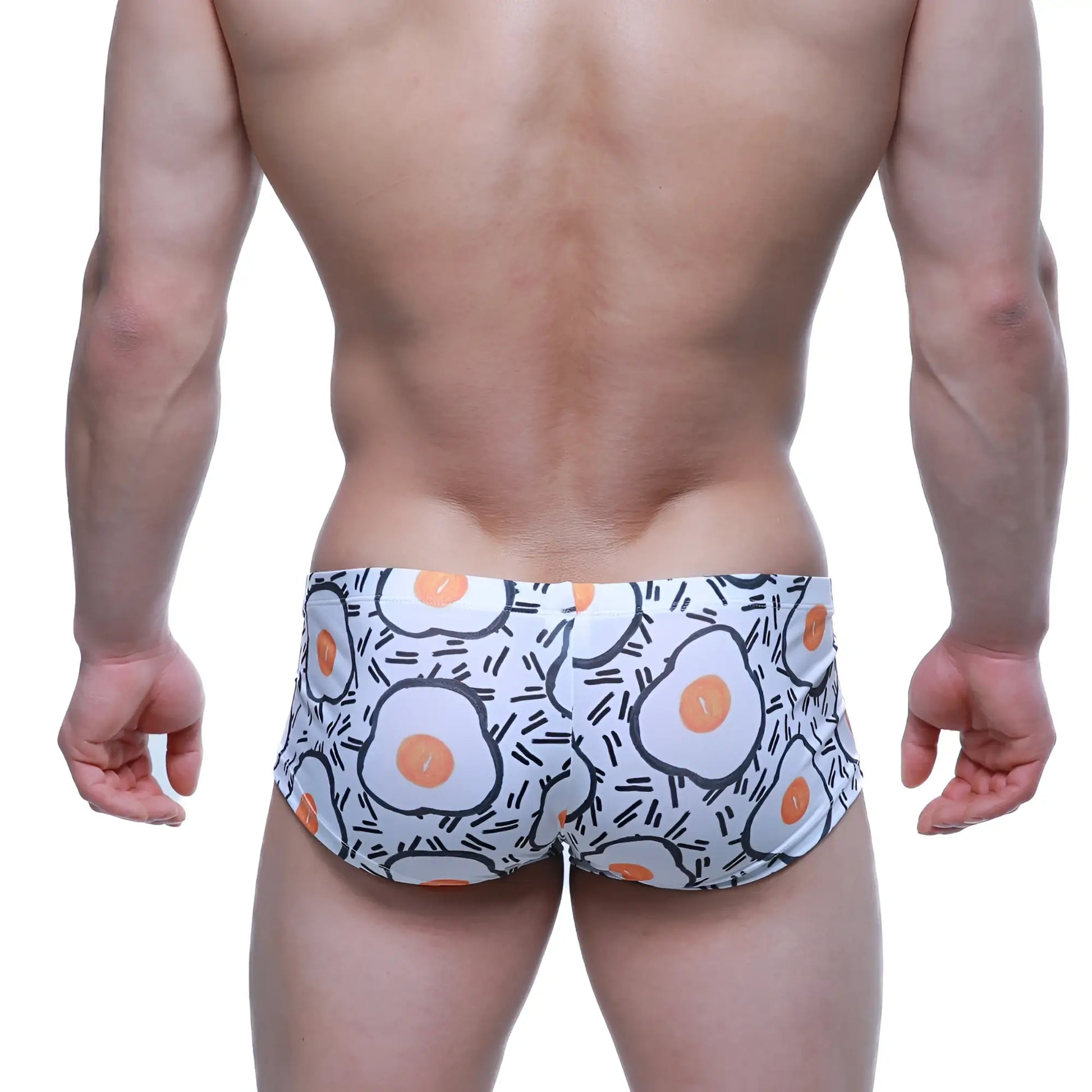 White swim trunks by metromalewear featuring a playful fried egg pattern with orange yolks and black outlines