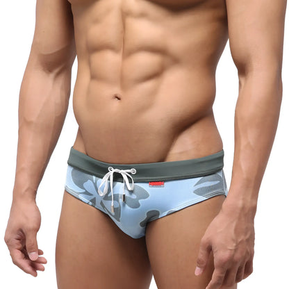 Light blue swim briefs with a gray camouflage pattern and white drawstring waistband.