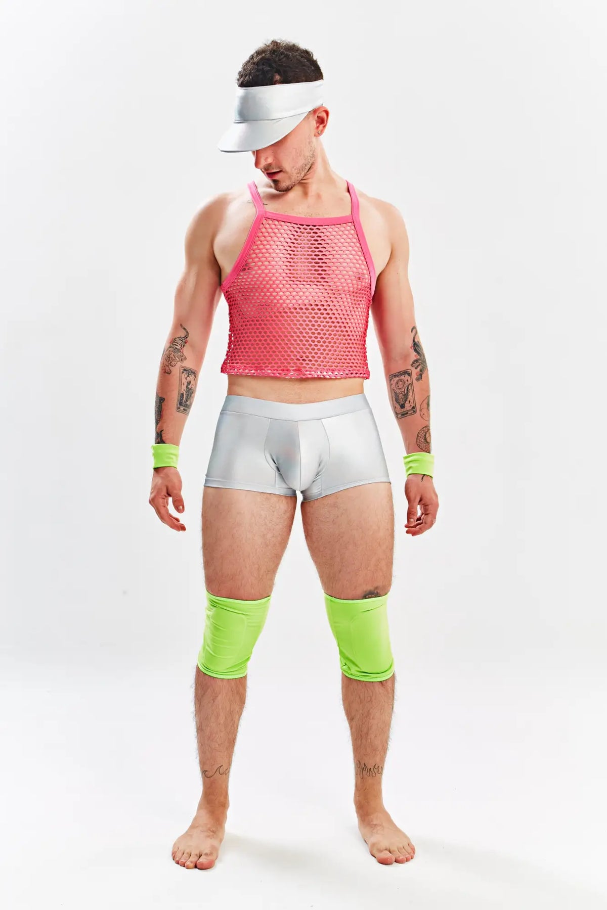 A man wearing a miami jock barbie menâ€™s sexy halloween costume with a bright pink mesh tank top silver briefs