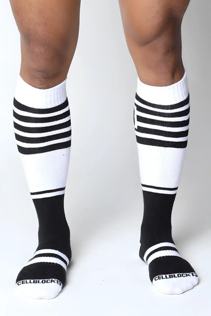 Black and white striped midfield knee high socks with ribbed texture and cellblock brand name on toe