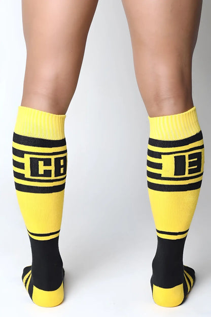 Midfield knee high socks in bright yellow and black with bold stripes and a prominent cb logo in the center