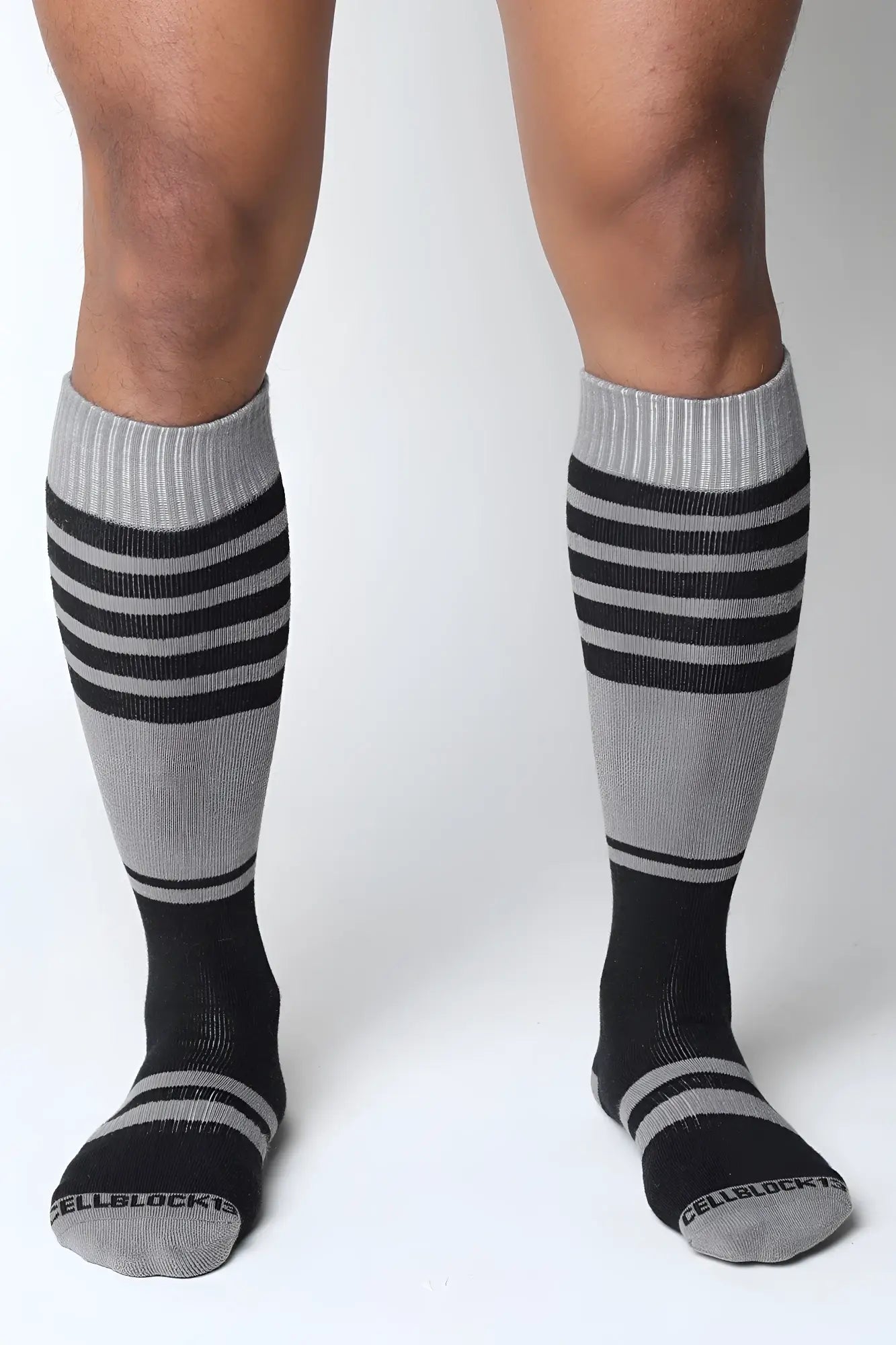 Gray and black striped midfield knee high socks with ribbed cuff and cellblock brand name on the toe