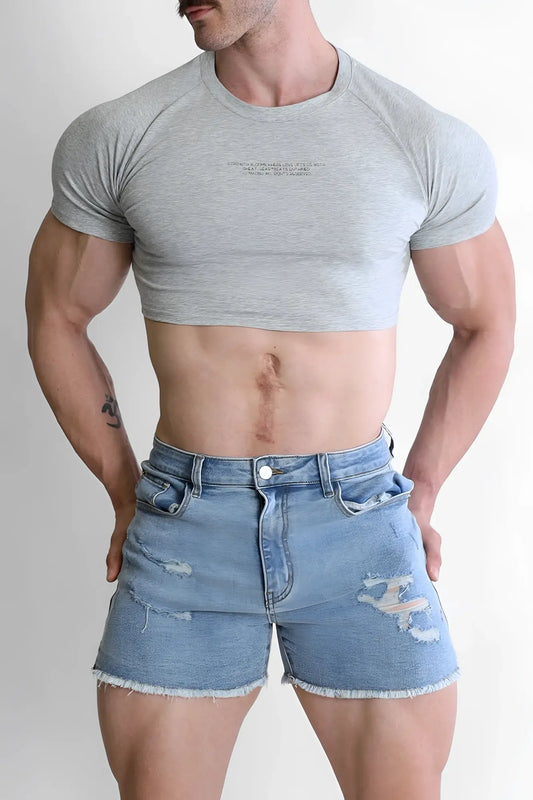 Gray muscle-fit crop tee with subtle chest text paired with distressed blue denim shorts for casual wear