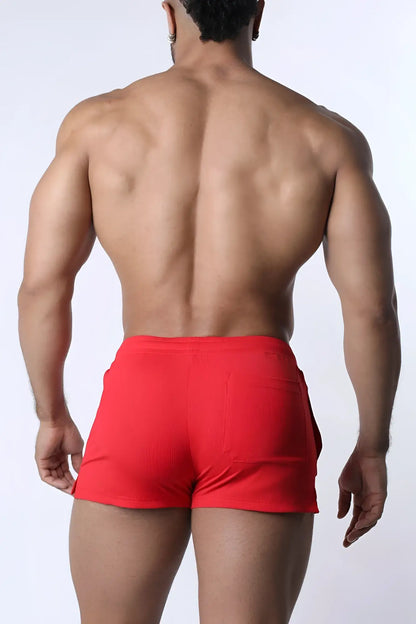 Red muzzle up athletic shorts with ribbed texture and side pockets designed for active wear