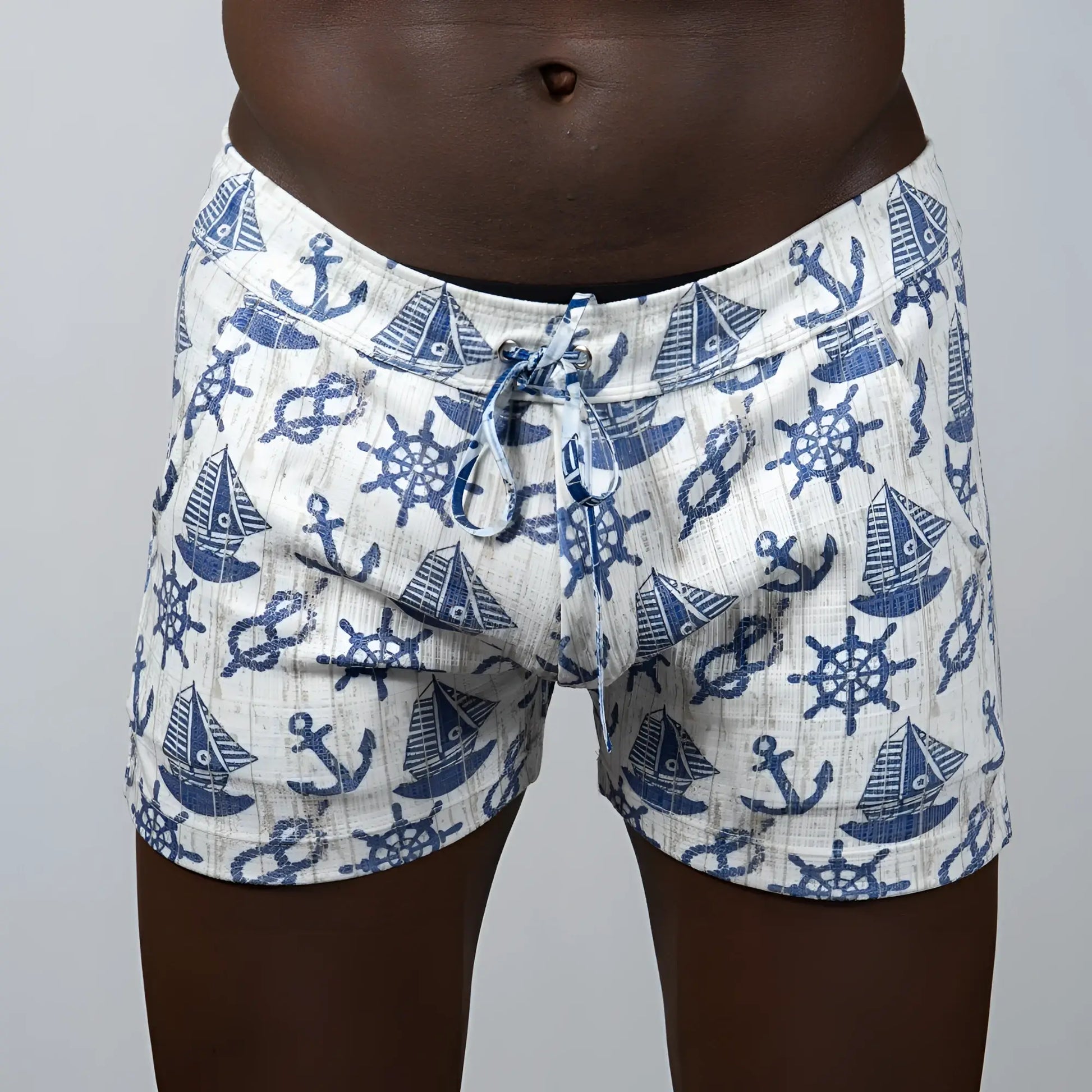 White linen texture shorts with blue nautical pattern of anchors sailboats and ship wheels in swim trunks style