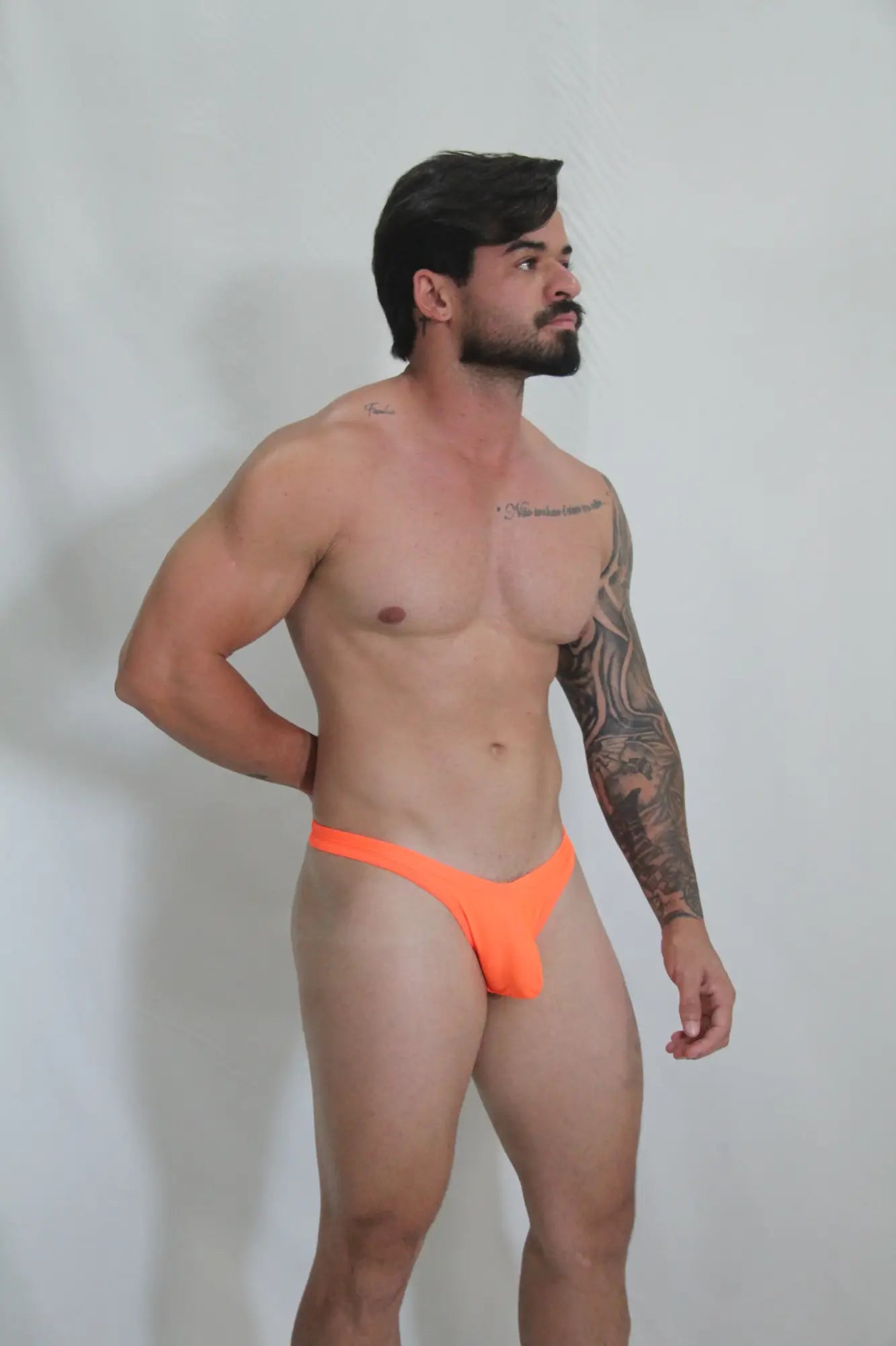 Bright orange neon swim thong with sleek minimalist design available in four vibrant colors for beachwear