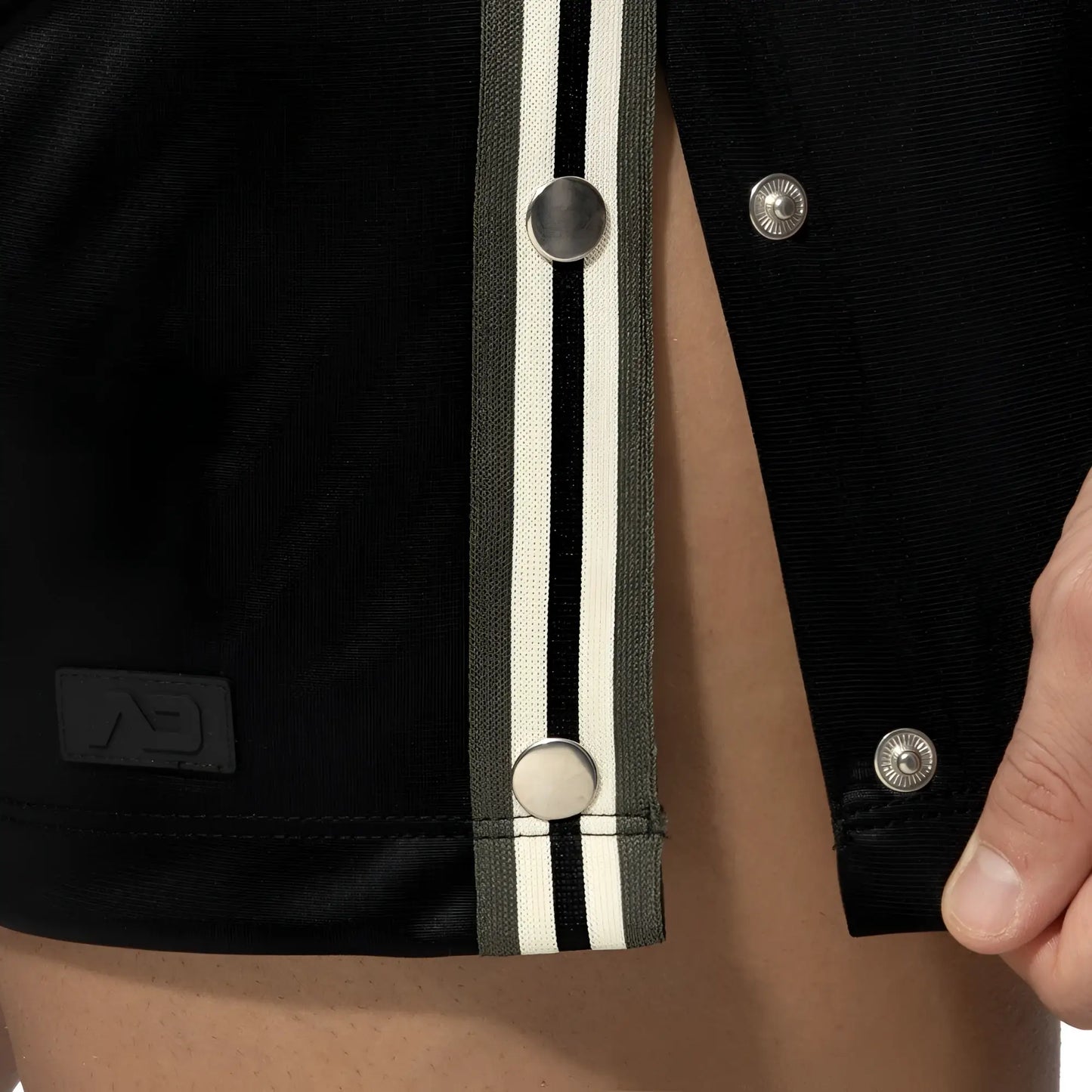 Black varsity jacket with olive and white striped placket and silver snap buttons shown with nexus button shorts