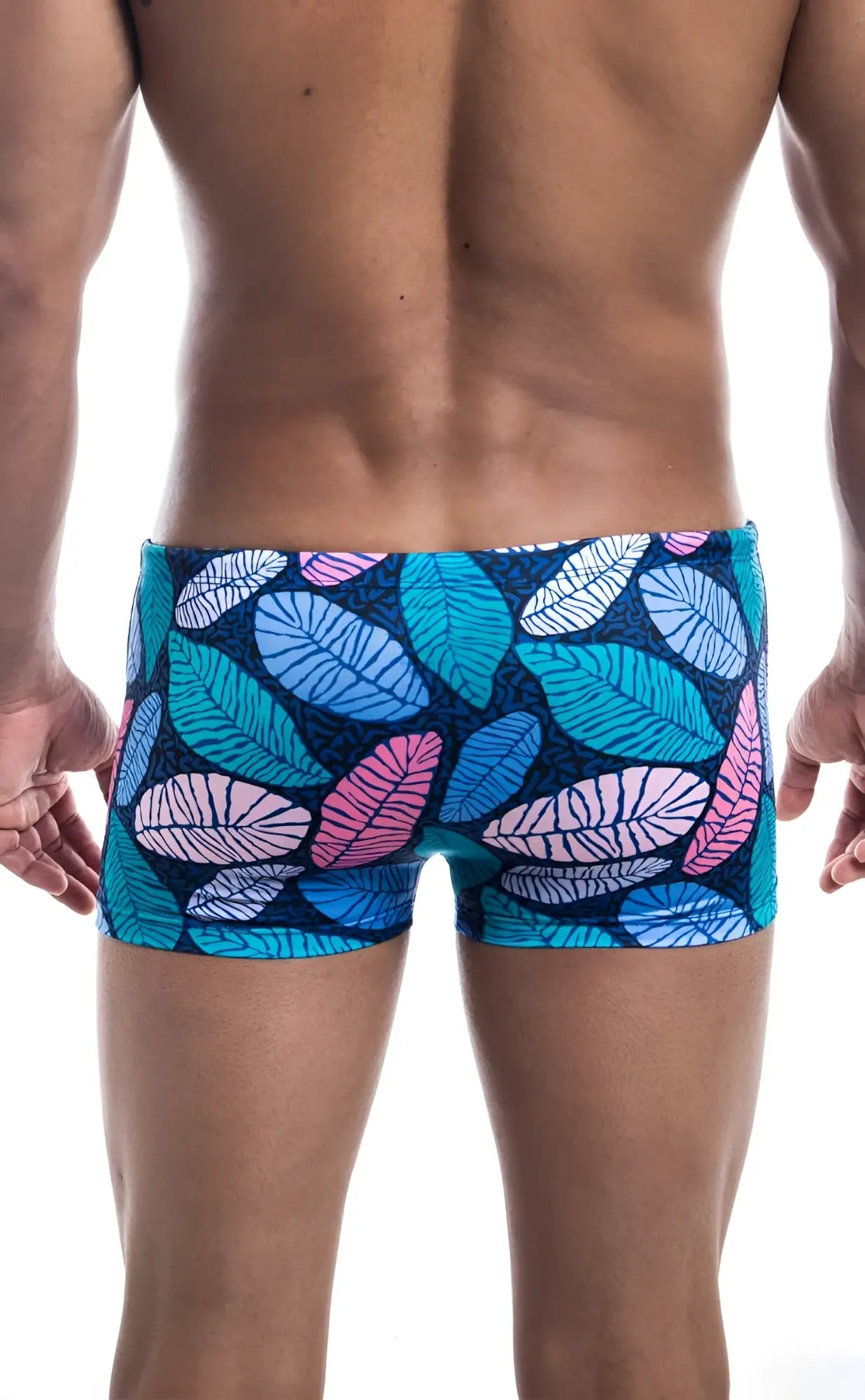 Oceanico square cut swim trunks with vibrant tropical leaf pattern in teal pink and white on dark blue base