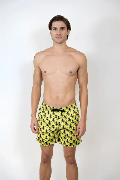 Bright yellow octopus print swim shorts featuring a repeating black octopus pattern for beachwear use