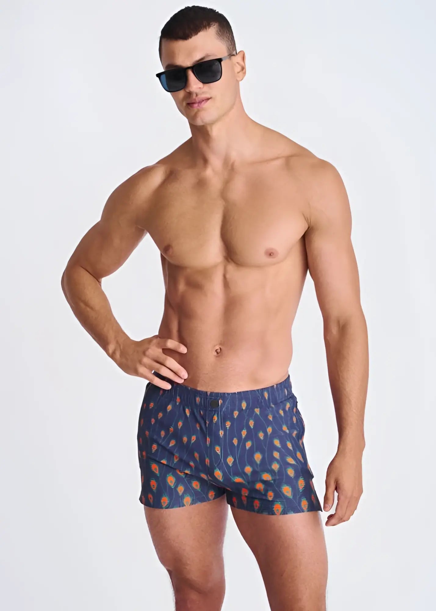 Blue peacock feathers seersucker swim shorts with orange and yellow feather pattern and mesh lining