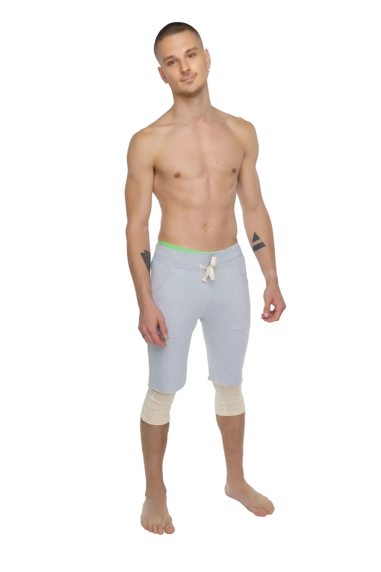 Light gray athletic shorts with neon green waistband and white drawstring paired with sand beige 3/4 performance yoga leggings