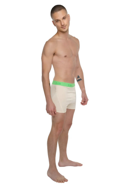 Cream-colored boxer briefs with bright green logo waistband paired with sand beige performance yoga leggings short