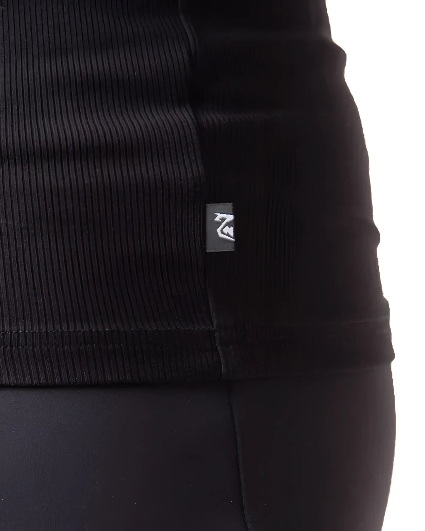 Black ribbed knit pig rib tank top with small rectangular brand tag on the seam showing the front side