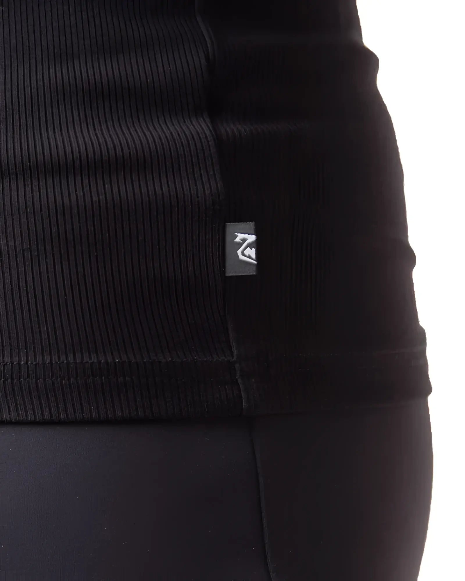 Black ribbed knit pig rib tank top with small rectangular brand tag on the seam showing the front side